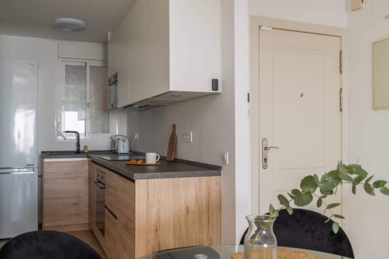 With its contrasting white and wood finishes, this kitchen is both highly functional and stylish. It's perfectly equipped with modern appliances.
