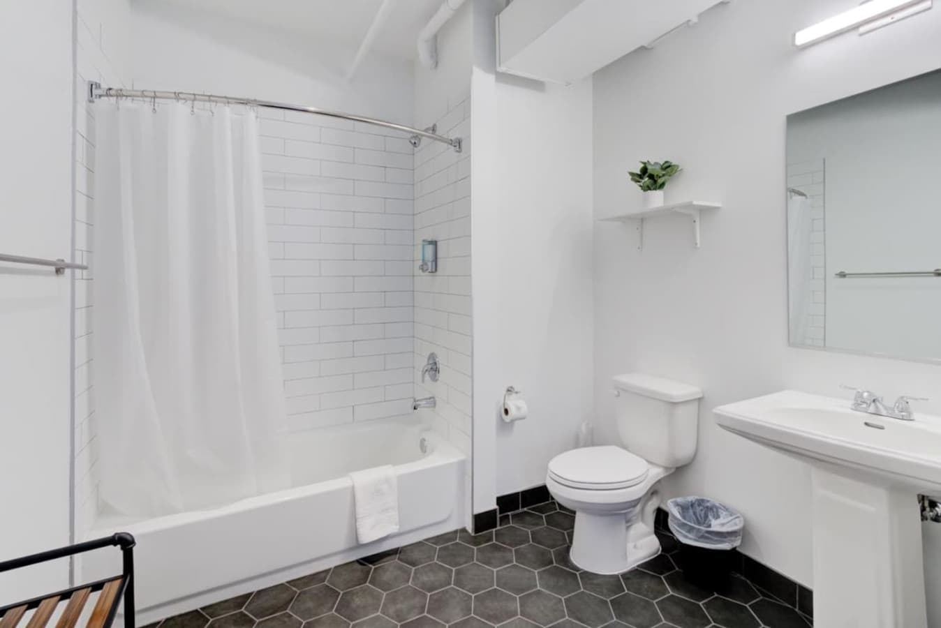Full-size bathroom with tub and all the essentials from soap, shampoo, and plenty of fresh clean white towels.