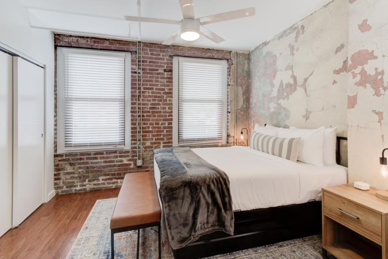 Bedside tables that are handy for trinkets and knick-knacks to keep your bedroom organized, a foot bench that gives you a comfy spot to tie your shoes, and a ceiling fan to make the room cooler.
