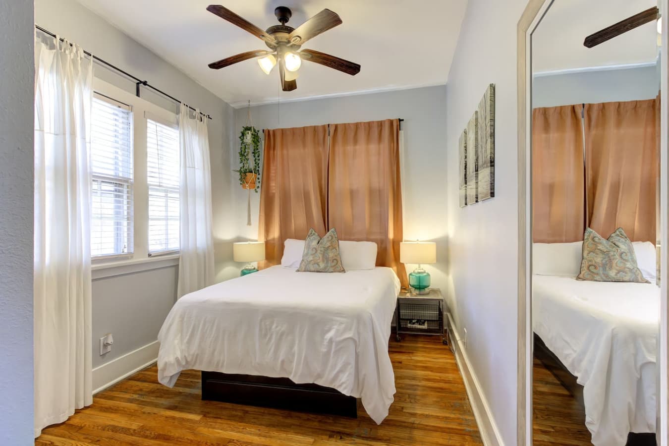 The bedroom invites you to relax, with soft natural light spilling through the windows and illuminating the bed adorned with plush pillows.