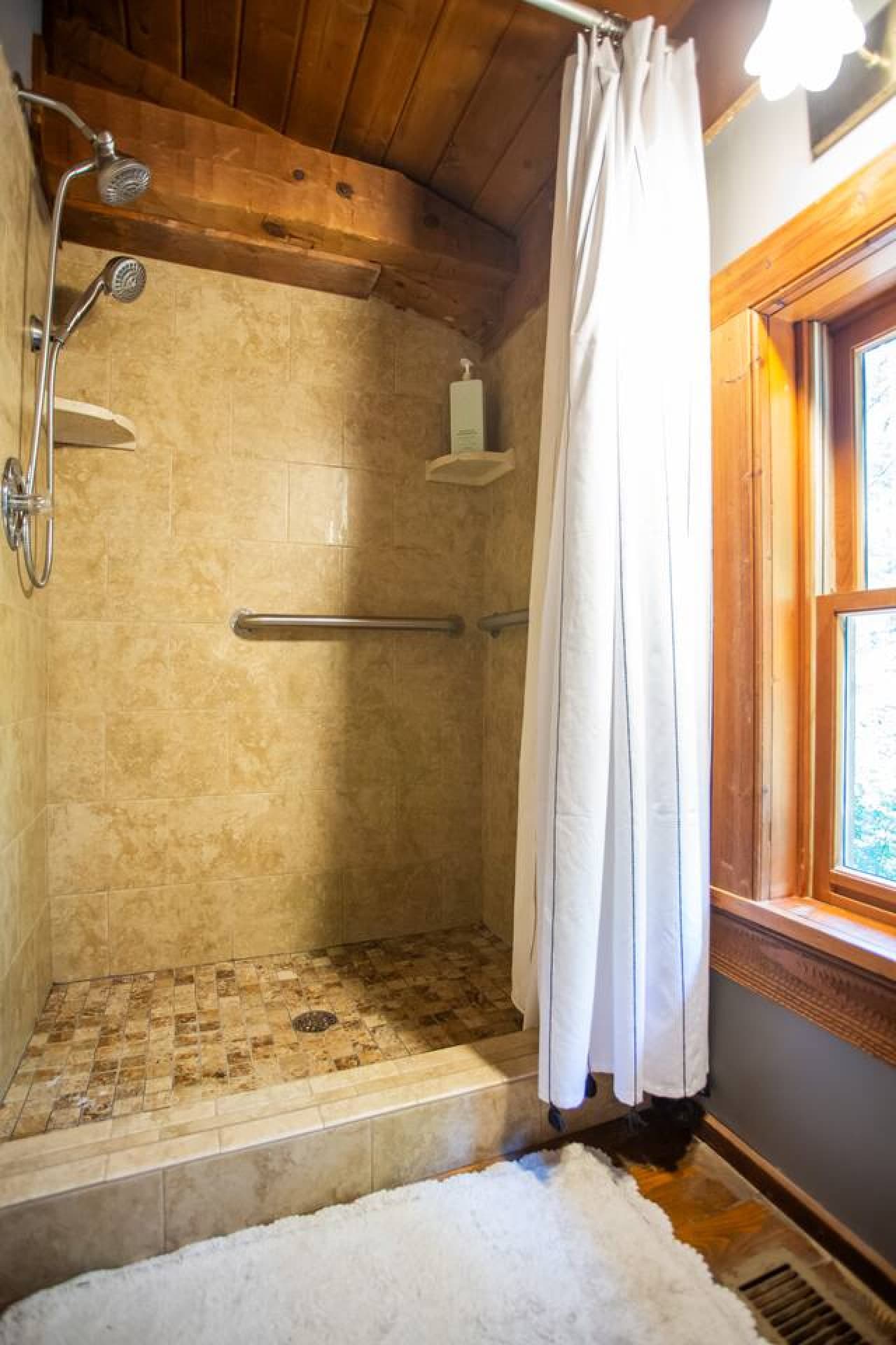 Step into a warm, wood-toned shower that feels like a cabin spa retreat.