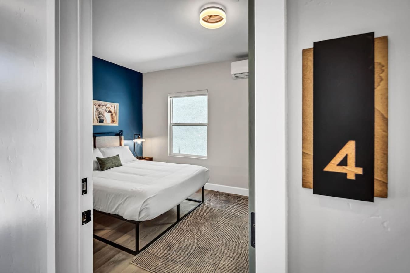 A beautifully lit, queen-sized bedroom with modern touches.