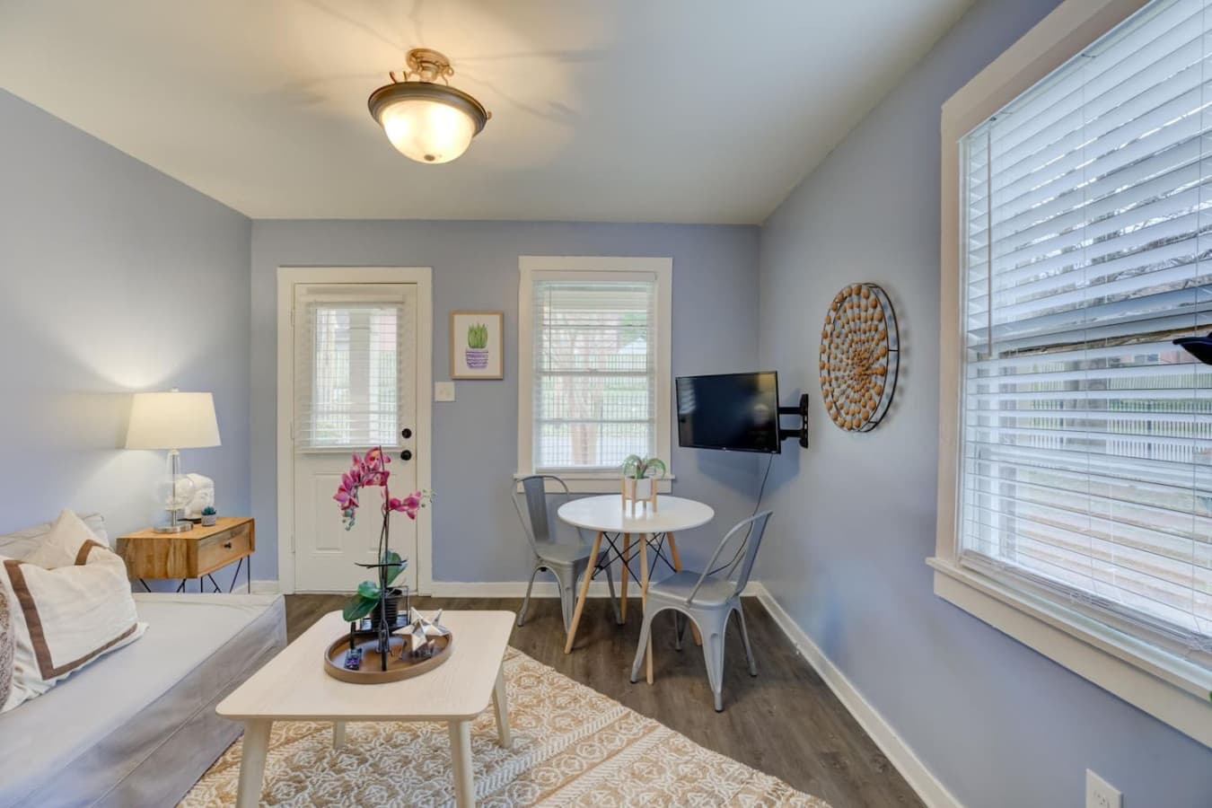 A welcoming space with a sofa, smart TV, and dining setup for two.