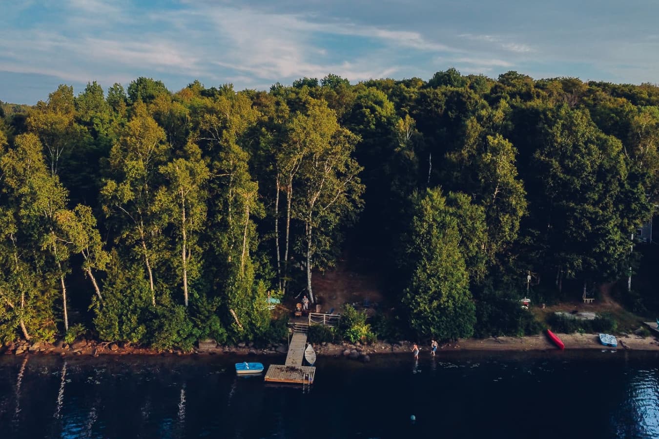 Bird’s-eye view of the property nestled in nature beside the lake, complete with a private dock.