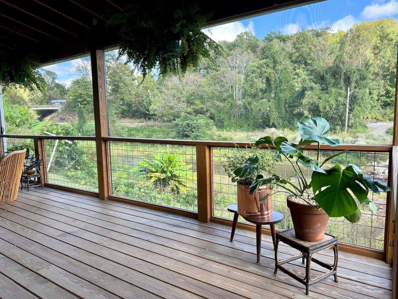 Creek, trees, and porch comfort—mountain bliss.