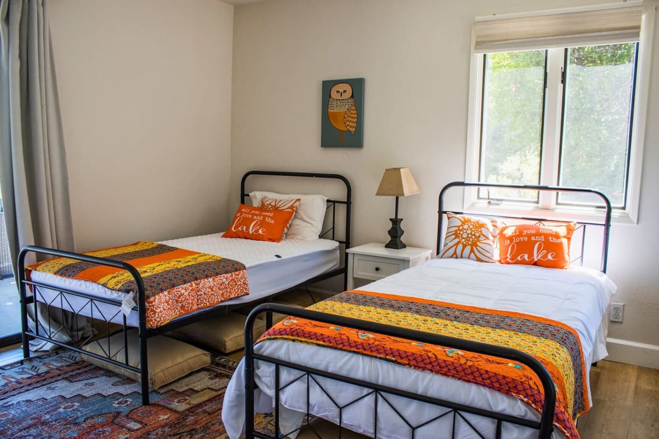 Charming first-floor bedroom with two twin beds, sliding doors to the porch, and an en-suite bathroom with a shower and tub, providing a comfortable and private space.