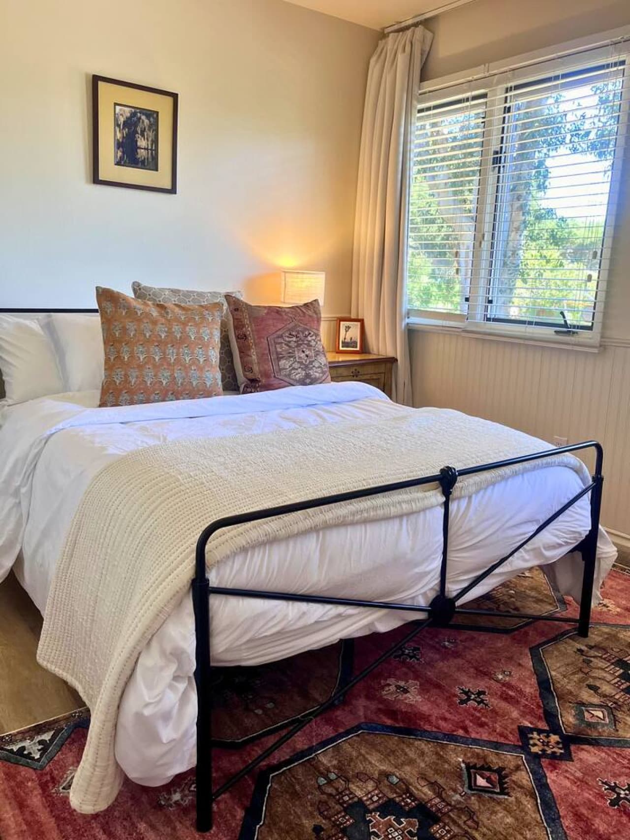 Cozy first-floor bedroom with a full bed, a closet, and direct access to the porch, offering a peaceful space to unwind and enjoy views of the surrounding greenery.