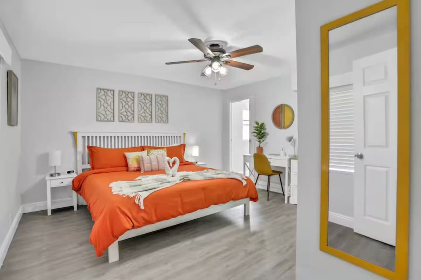 White walls, orange accents, and plenty of sunshine—this room might steal your productivity (in the best way).