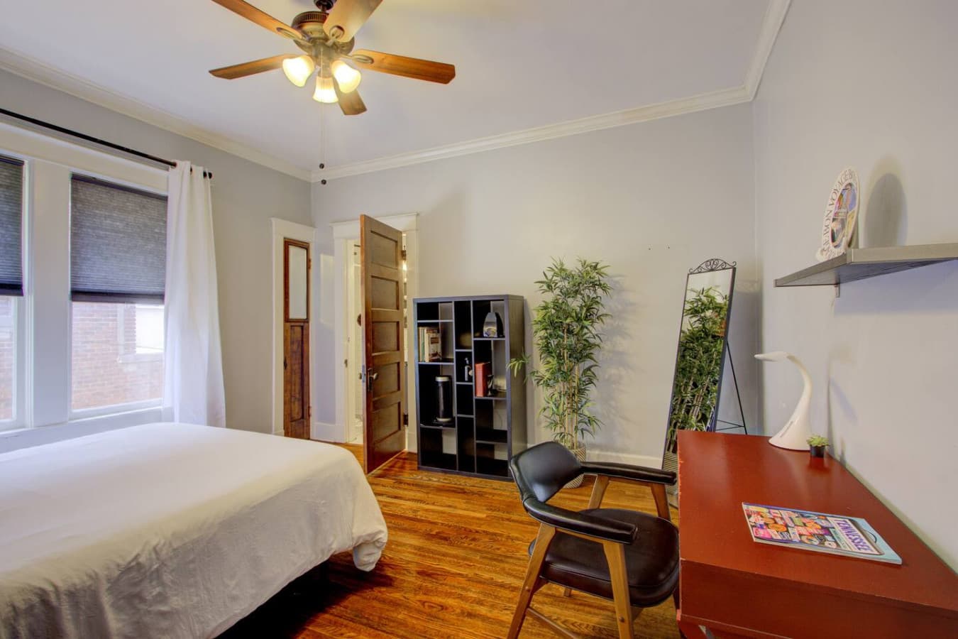 Inviting space with a desk, mirror, and shelving, perfect for work or relaxation.