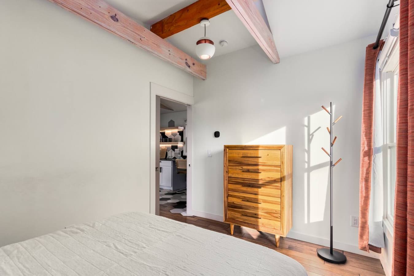 A minimalist bedroom with a queen bed and soft, welcoming energy for your stay.
