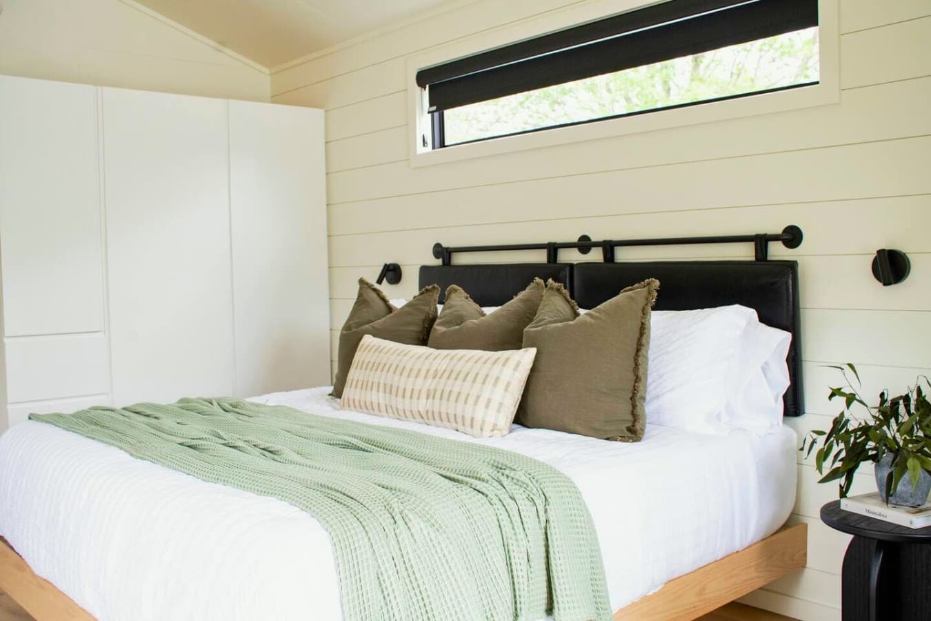 Drift off to the sound of the bay in a plush king bed, surrounded by soft lighting and calm coastal charm.