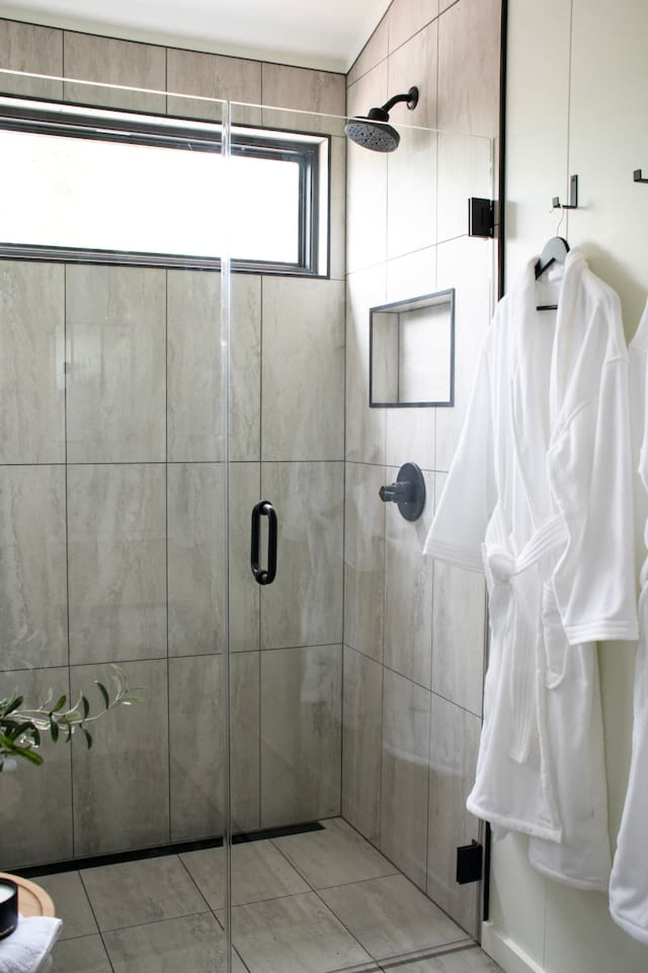 Enjoy a sleek, separate shower with fresh towels and essentials for a refreshing coastal start to your day.