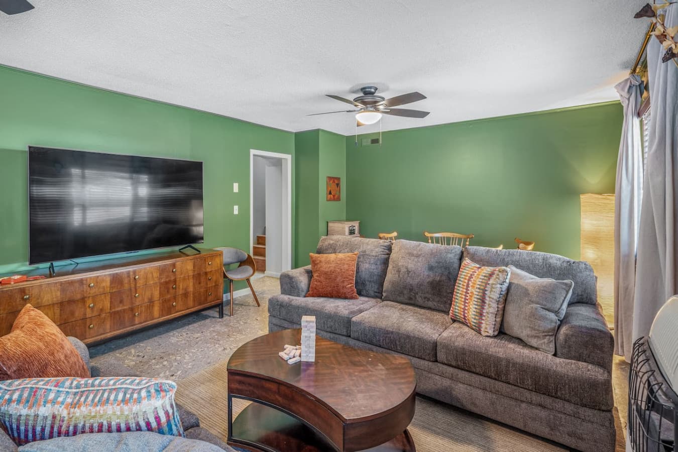 Spacious living room with soft seating, smart TV, and plenty of cozy corners to relax after a day outdoors.