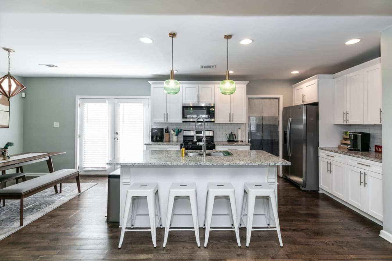 Stunning granite countertops and bright white cabinetry create a clean, contemporary kitchen aesthetic.