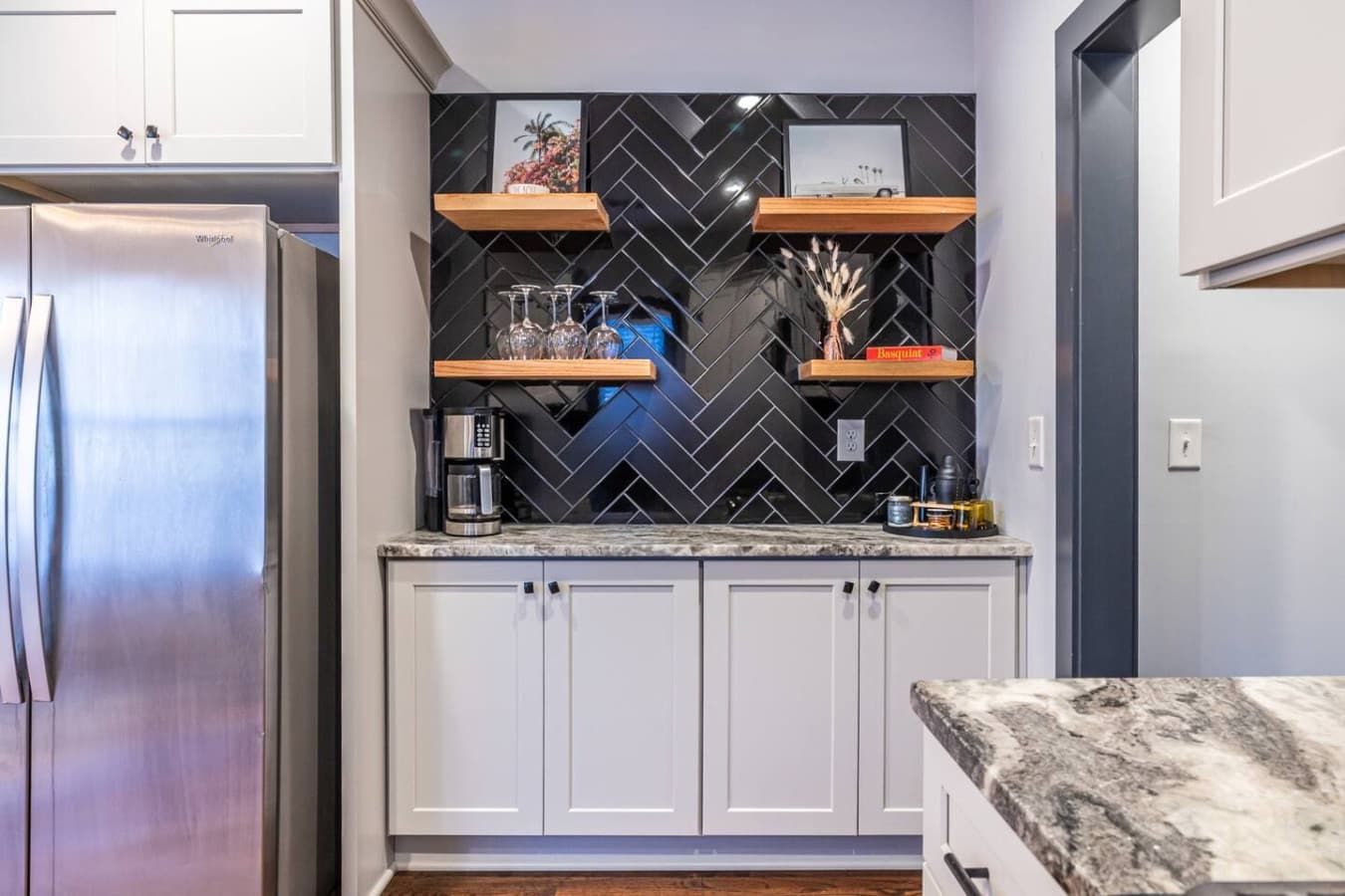 A contemporary kitchen with floating shelves and chic black tile, offering both function and flair for cooking or entertaining.