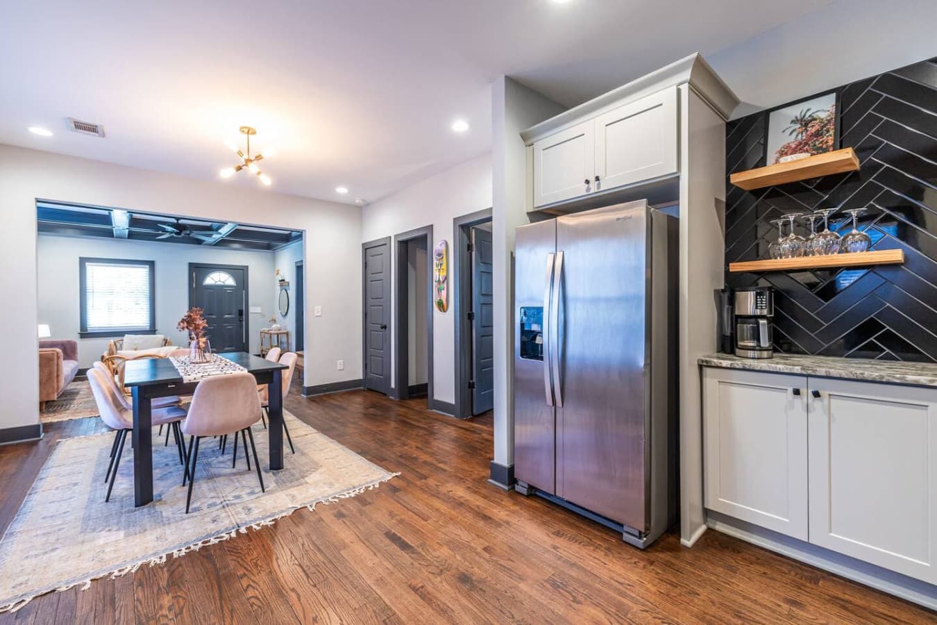 A contemporary kitchen with floating shelves and chic black tile, offering both function and flair for cooking or entertaining.