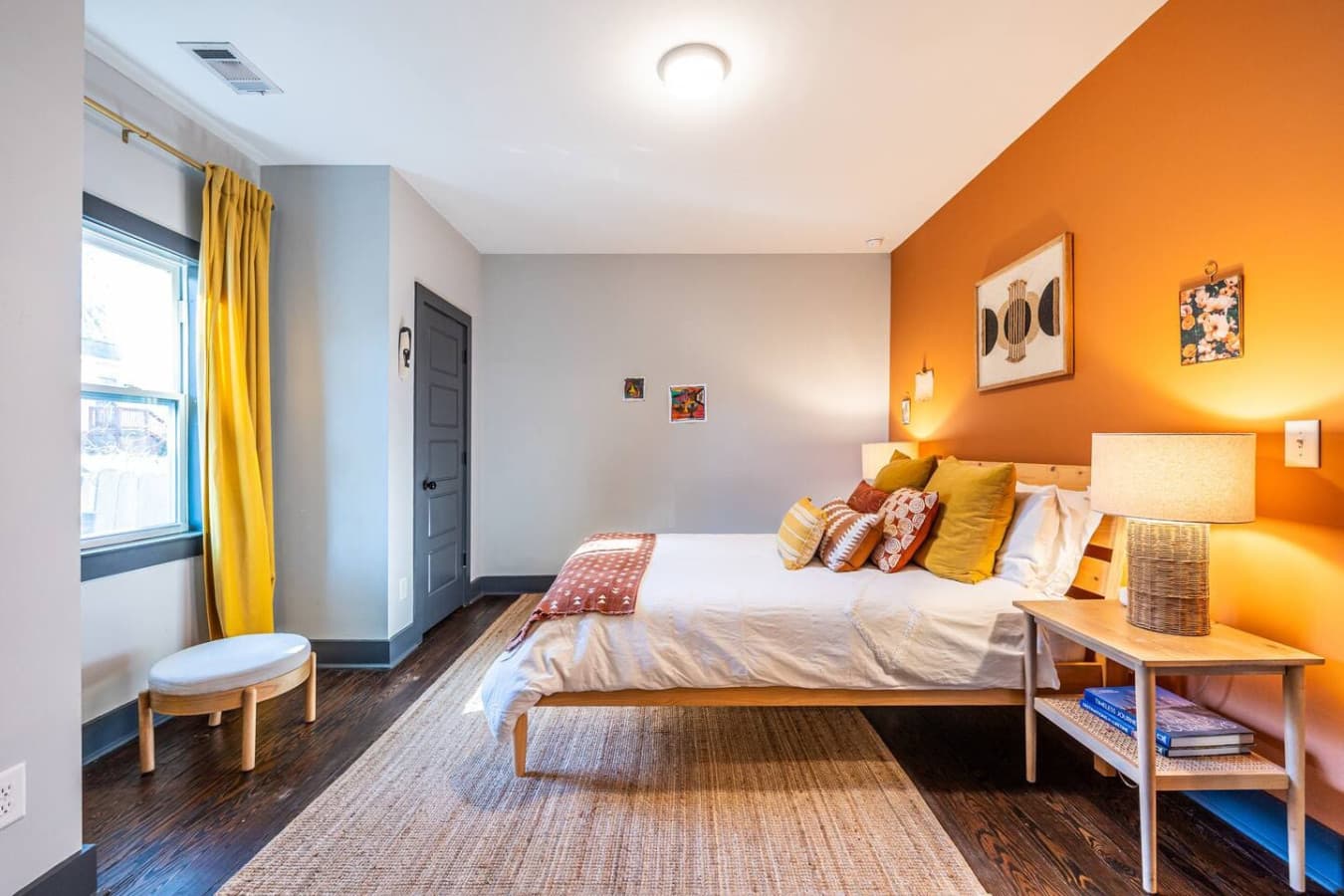 Relax in this vibrant guest room, complete with a queen bed and warm, inviting colors that make the space feel homey.