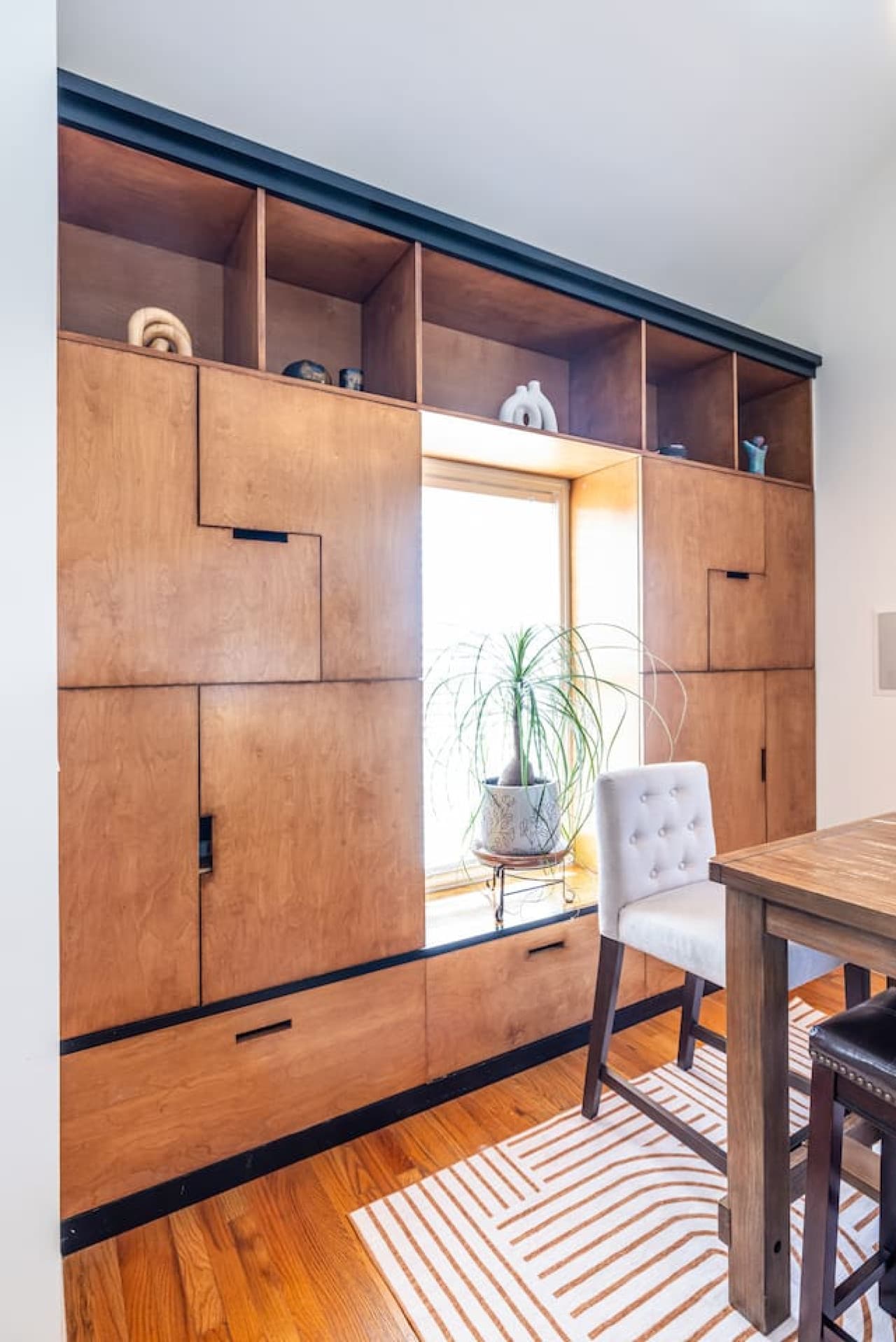 Mid-century–inspired cabinetry adds warmth and personality to this bright dining space.