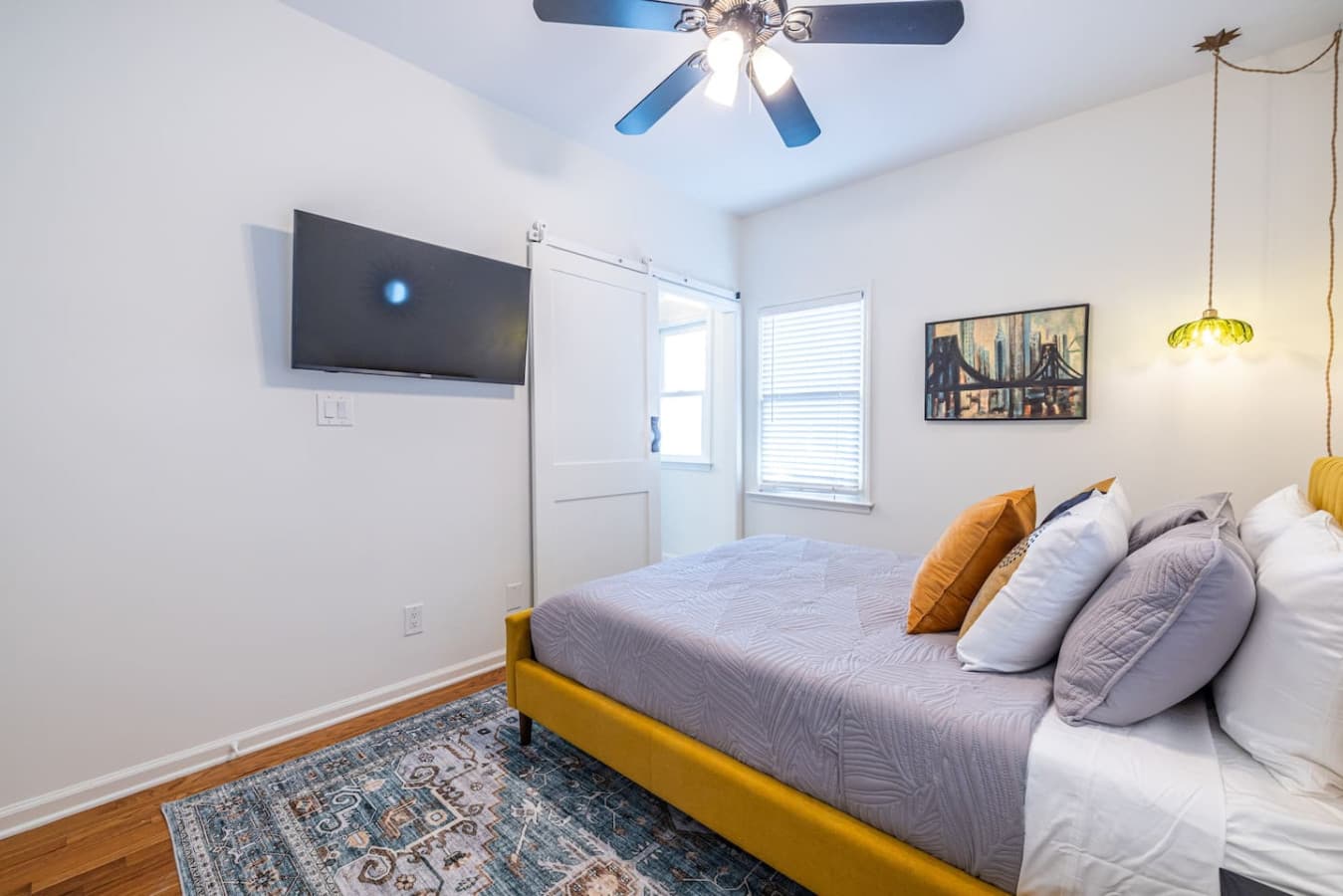 Light-filled primary suite with a comfortable bed and entertainment at your fingertips.