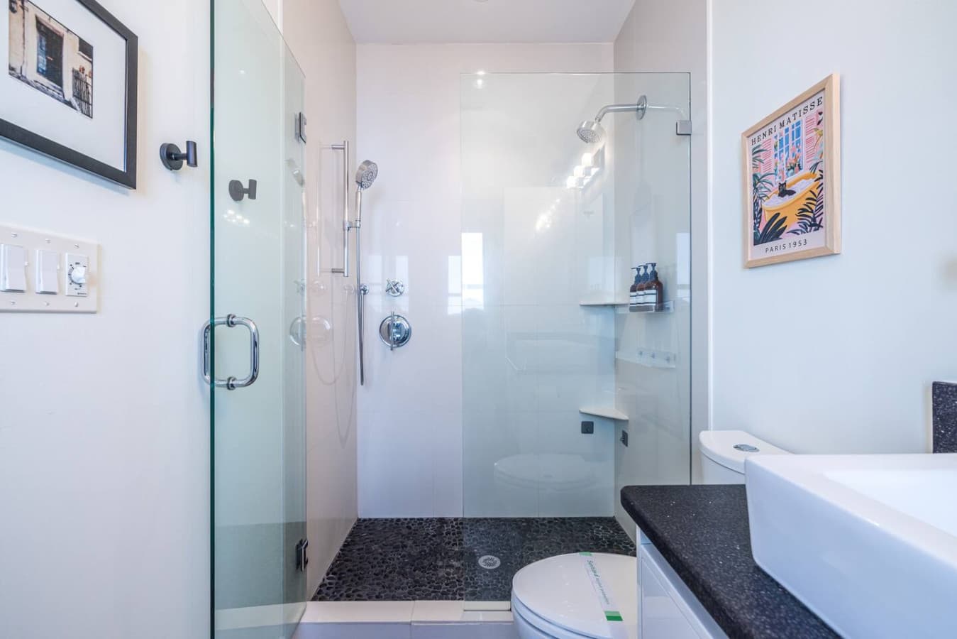 Bright glass walk-in shower with dual shower heads for a spa-like experience.