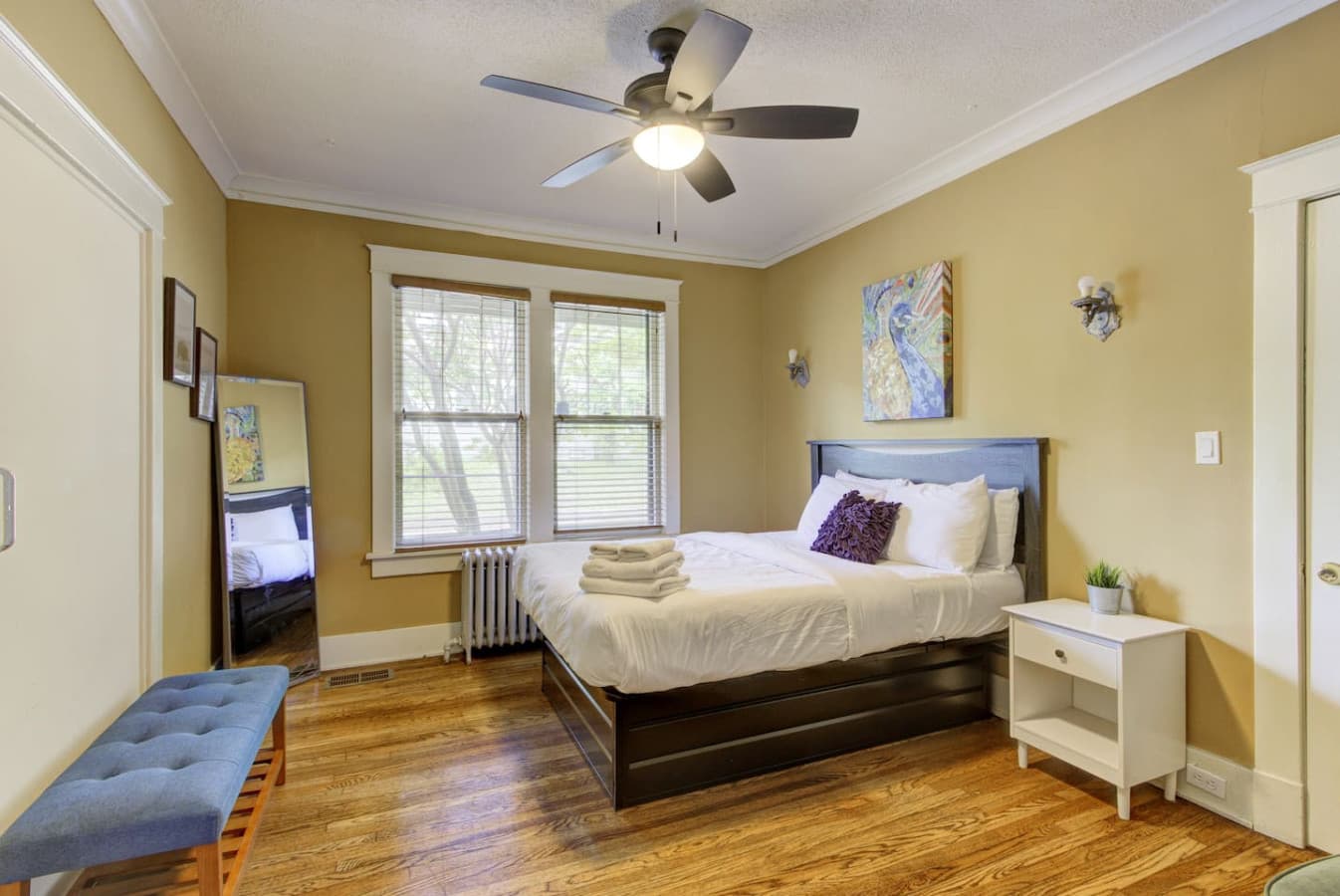 Wake up to natural light streaming through large windows in this spacious bedroom.