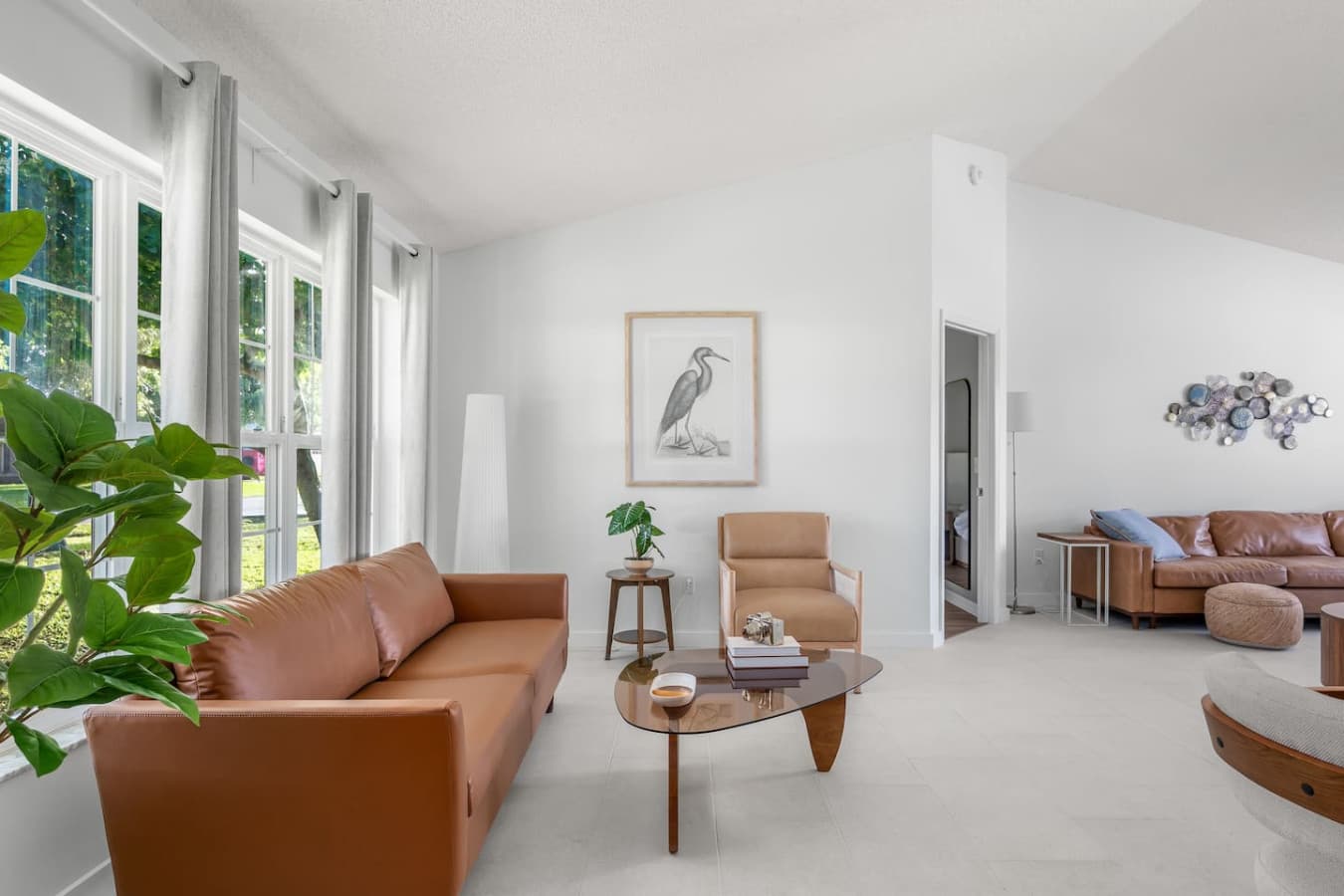 Spacious living area with natural light, offering plenty of room to sit back and enjoy the leather sofas.