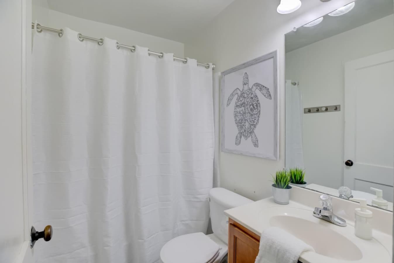 Full-size bathroom with a tub and all the essential soaps and fresh clean white towels