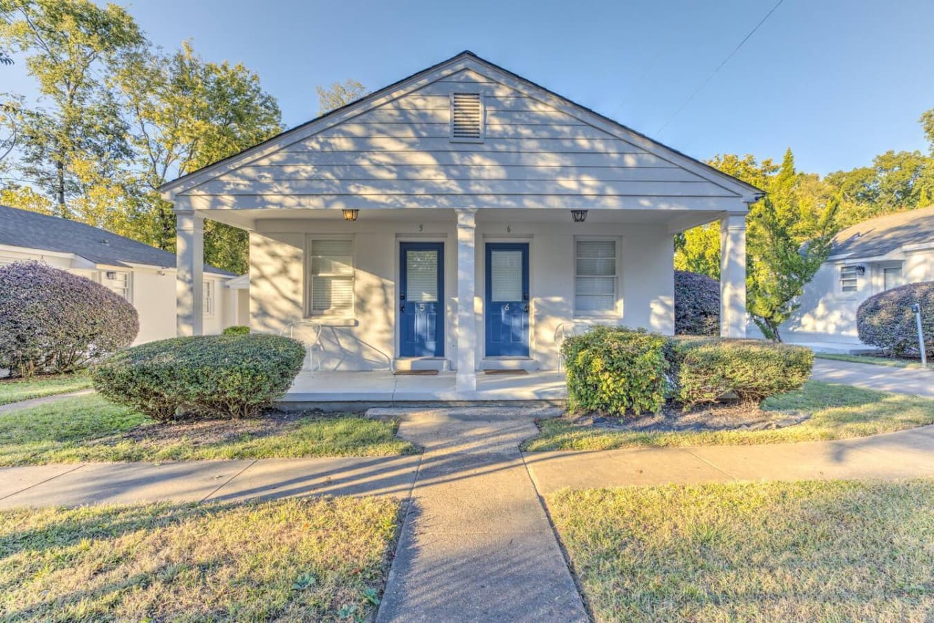 White cottage, blue door, and all the Southern charm you could ask for.