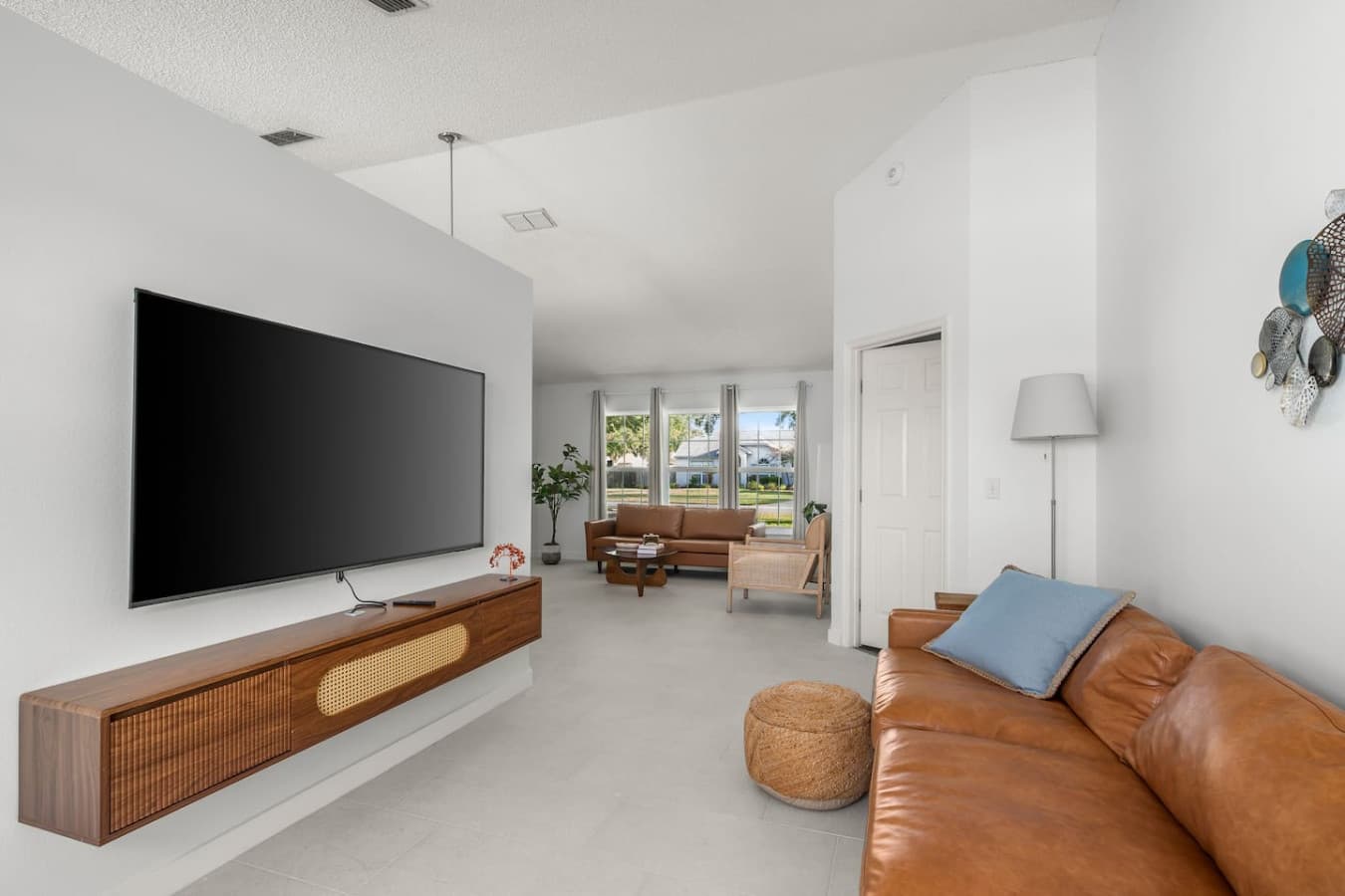 Open-concept living room with generous seating, soft leather sofas, and a TV perfect for movie nights.
