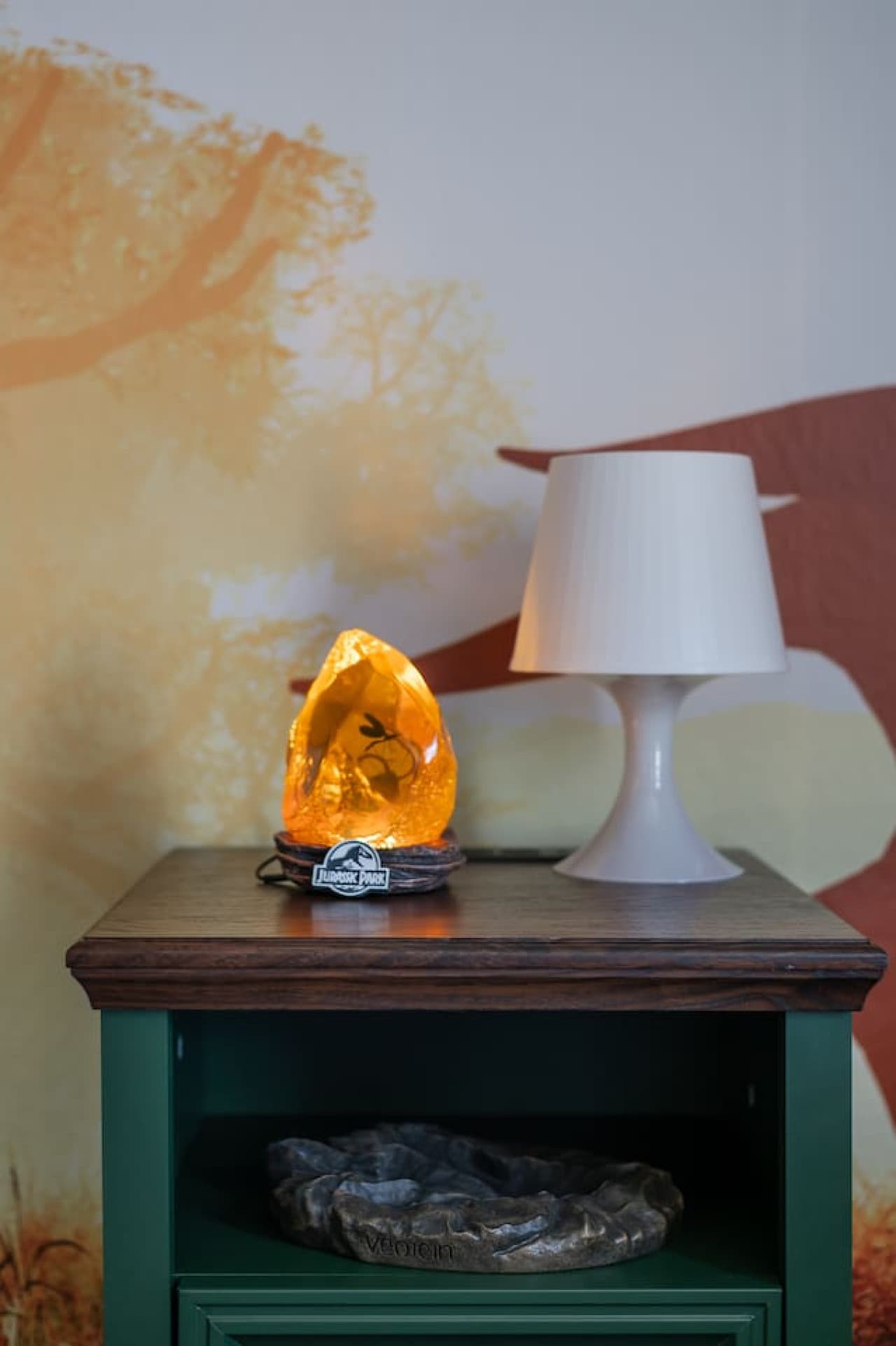 Jurassic vibes come alive with playful dinosaur decor and a cozy bedside lamp glow.