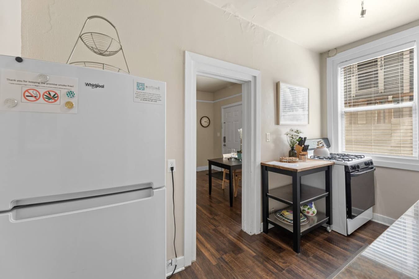 Fully equipped kitchen with ample counter space, shelving for storage, and a fridge, making meal preparation a breeze.