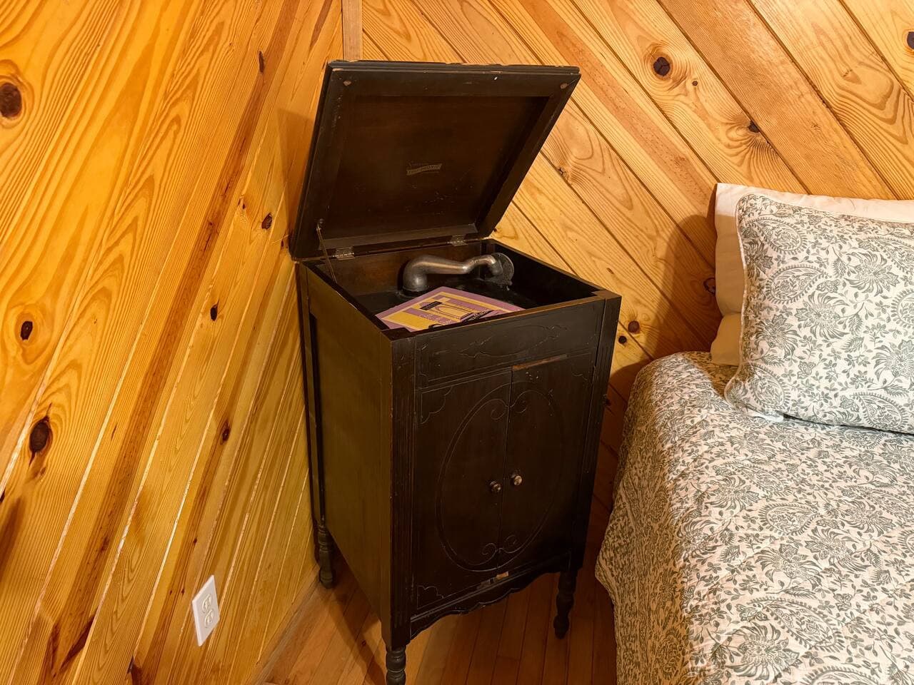 A vintage-style turntable adding a touch of old-school charm right by the bed.
