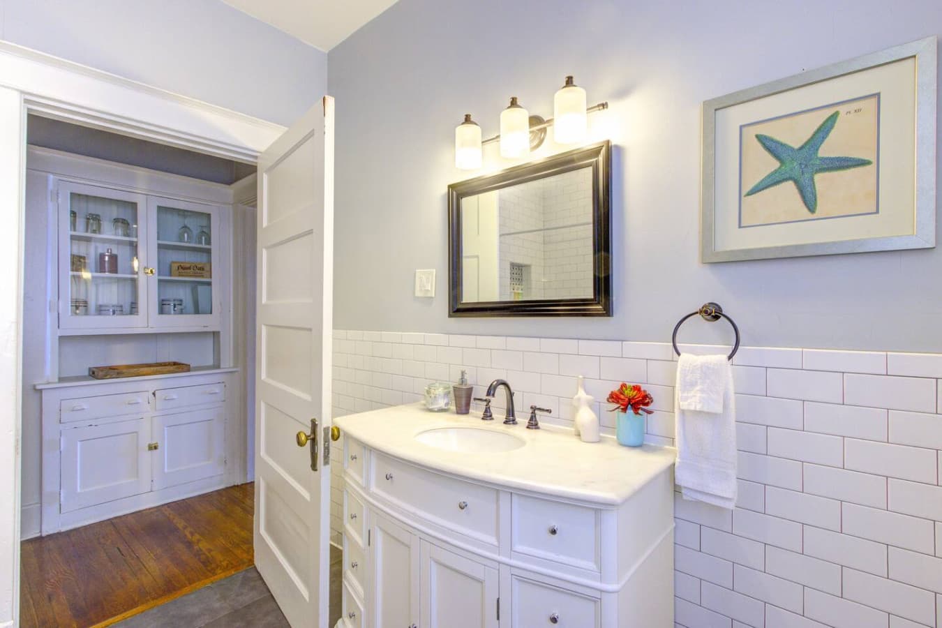 Fully renovated bathroom, complete with a sink and a charming mirror.