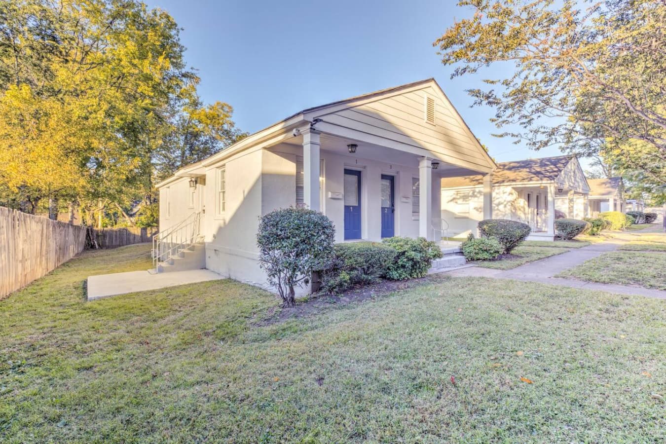 A touch of Southern magic behind the gate—white cottage, blue door, big heart.