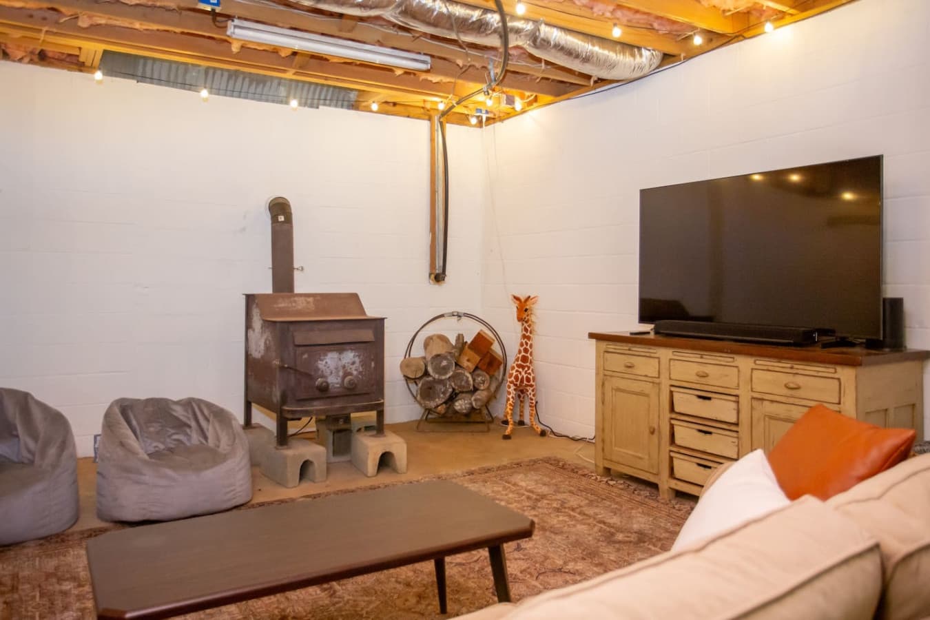 Cabin on the Haw: Kick back and relax in the cozy basement lounge with a 65" smart TV for entertainment.