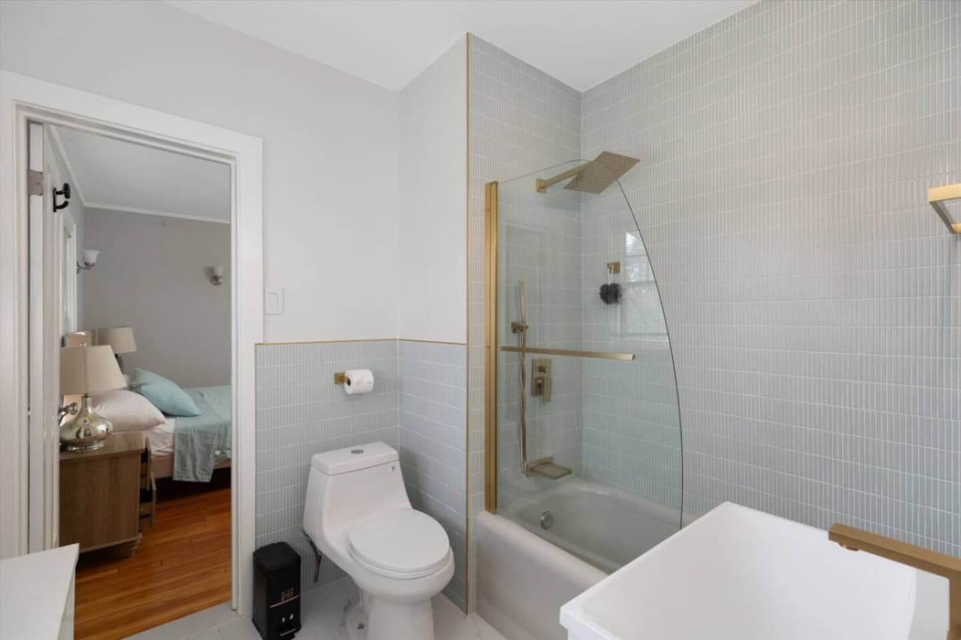 A contemporary, bright bathroom featuring a tub/shower combo, ideal for beginning or winding down your day.