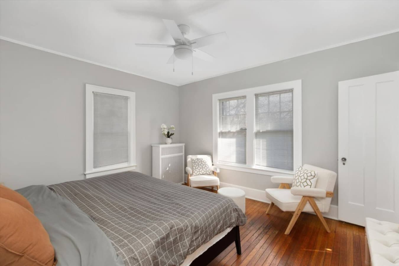 Bright and airy, this room features a queen bed and a pair of chic white armchairs for relaxing.
