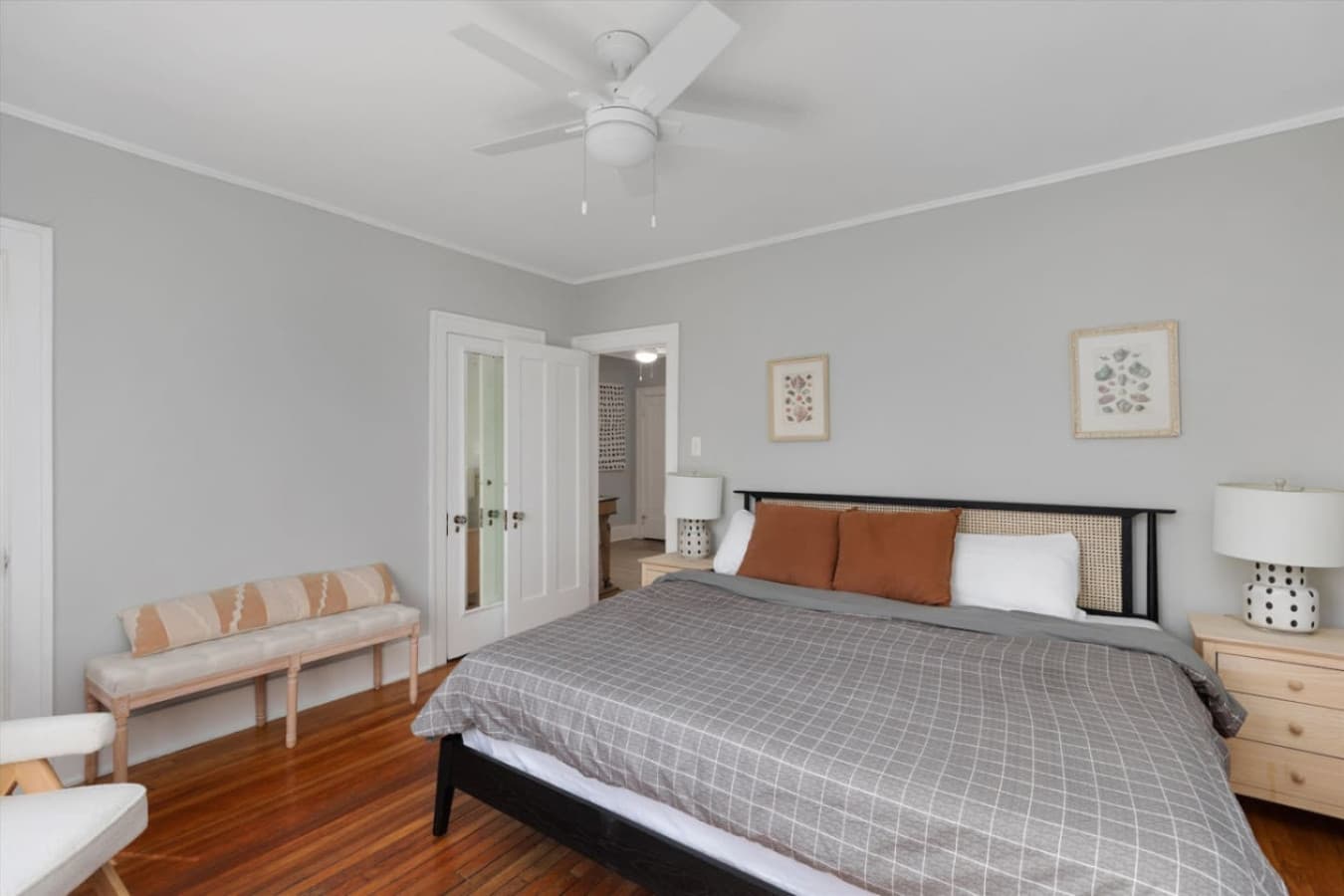 A sun-filled queen bedroom with two cozy white armchairs—perfect for reading or morning coffee.