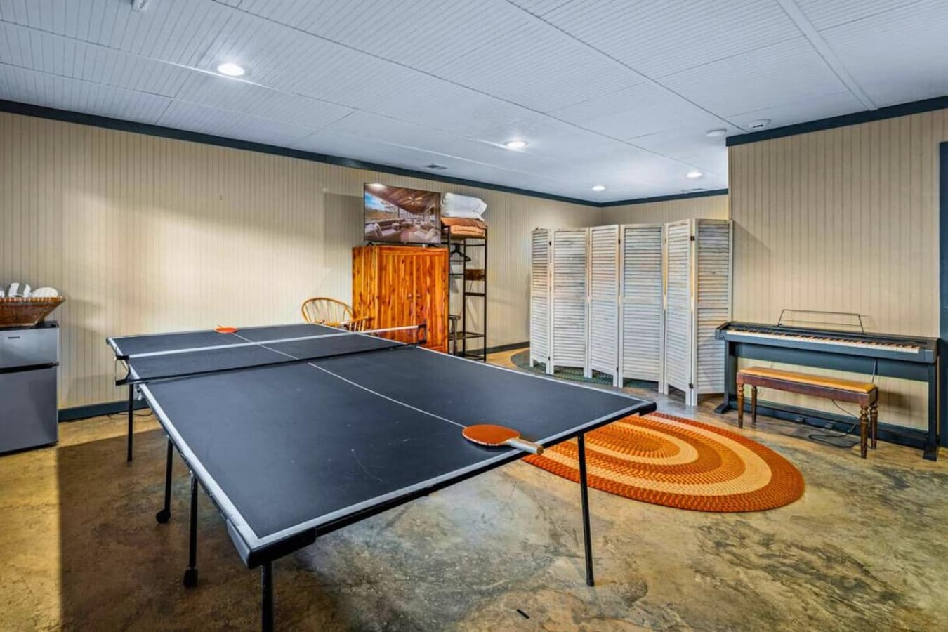 Bedroom 3/Game Room featuring a ping pong table, smart TV, two twin beds, sleeper sofa, full bathroom (tub/shower), and a mini fridge.