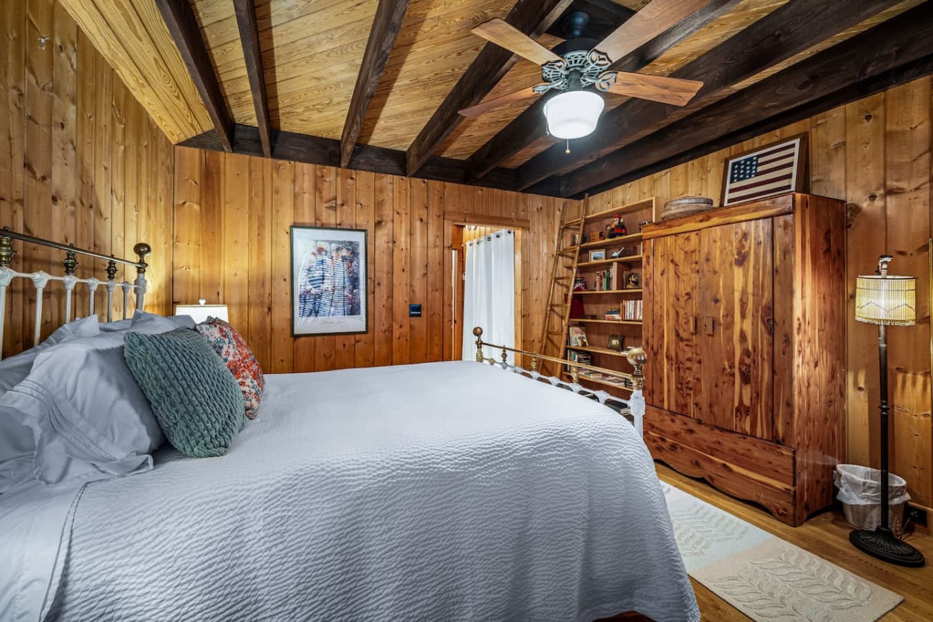 Bedroom 1 on the main floor with an attached full bathroom, featuring a king bed, armoire, and a make-up table.