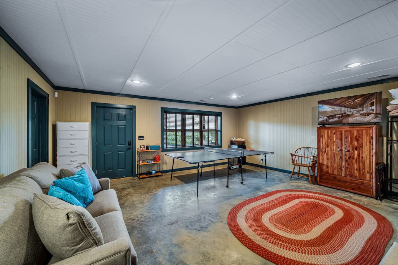 Bedroom 3/Game Room featuring a ping pong table, smart TV, two twin beds, sleeper sofa, full bathroom (tub/shower), and a mini fridge.