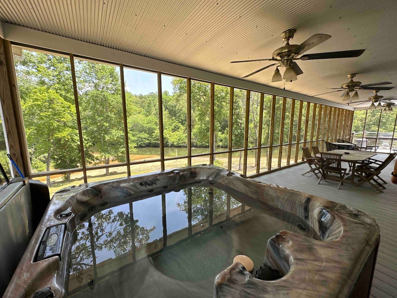 Serene spa setting on the screened porch, offering a peaceful soak with tranquil river views.