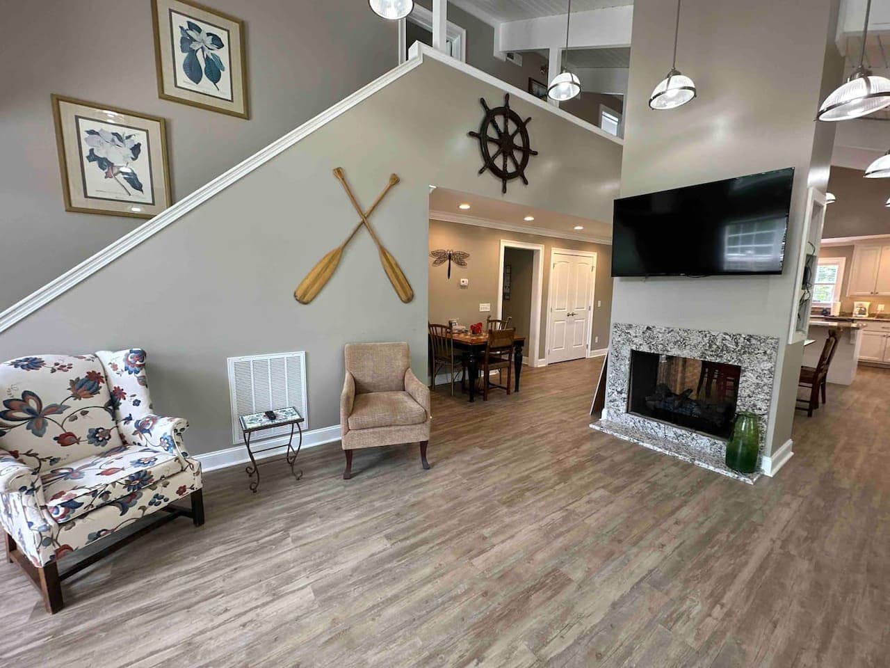 Elegant open living area blending rustic warmth with modern comfort, highlighted by high ceilings and detailed nautical décor.