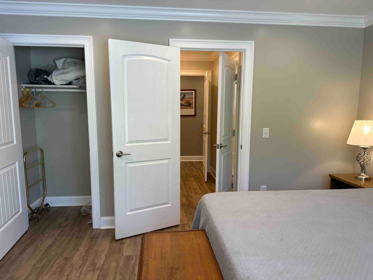 Inviting room with a queen bed, walk-in closet, and private bath. Bright and elegant with wood flooring, warm décor, and a classic wooden chest at the foot of the bed.