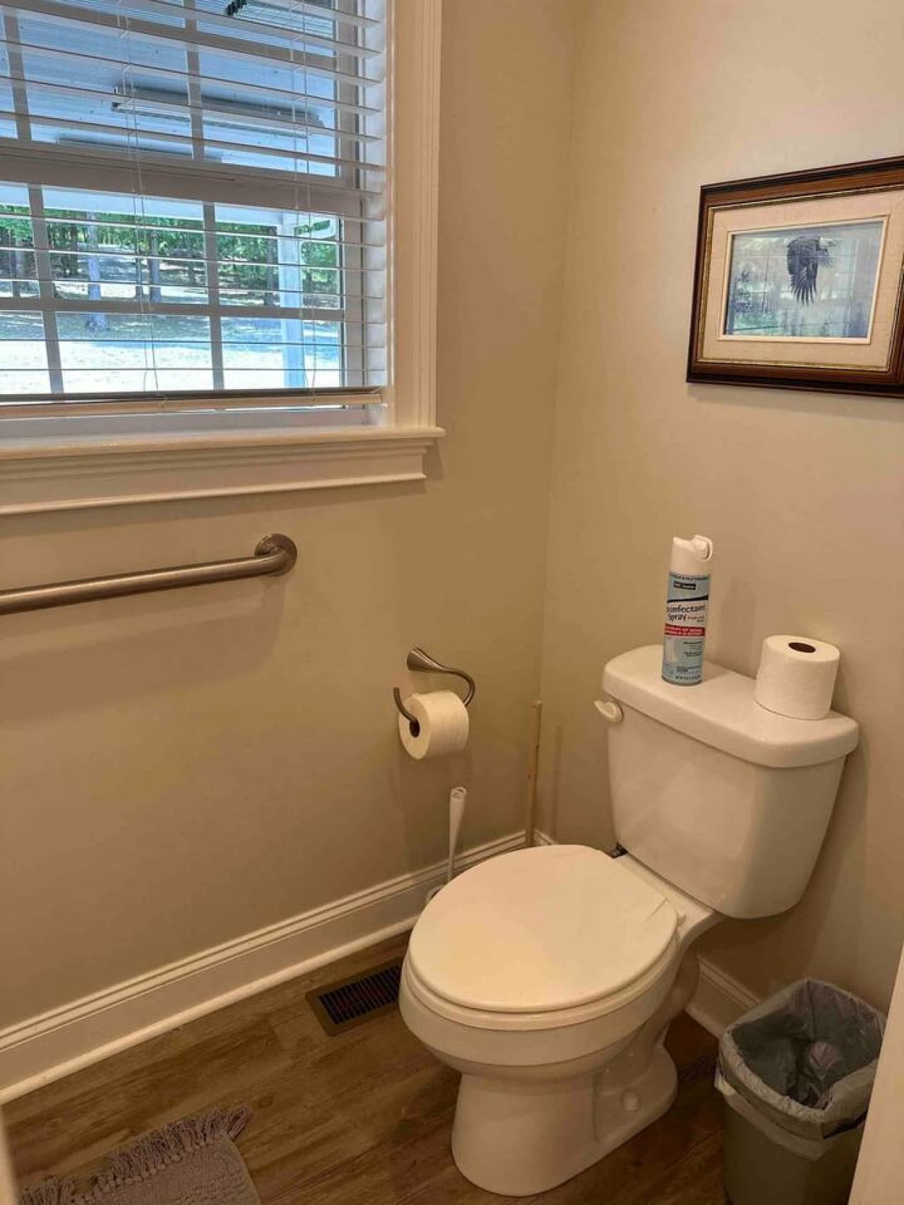 Private toilet area within Bedroom 4’s ensuite, featuring a standard toilet, grab bar, window with blinds, and wood-style flooring.