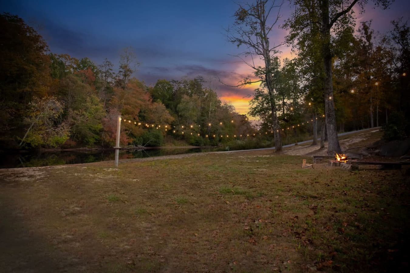 Cozy evening vibes by the river under twinkling lights.