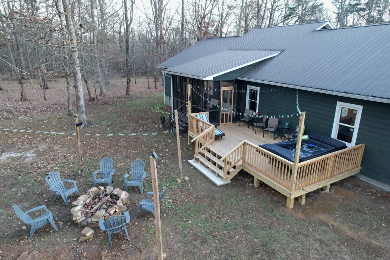 Step into the backyard at The Bird House, where a spacious deck and large back porch invite you to unwind—soak in the bubbling hot tub, relax in the cozy screened-in porch, or gather around the glowing fire pit under the stars.