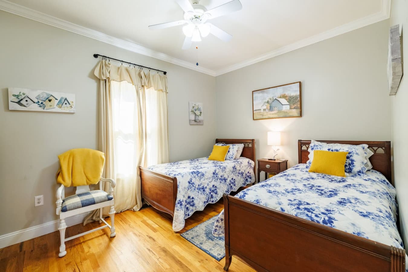 Bright and cheerful twin bedroom with floral bedding, sunny yellow accents, and warm natural light—perfect for friends, kids, or anyone ready for a cozy night’s rest.