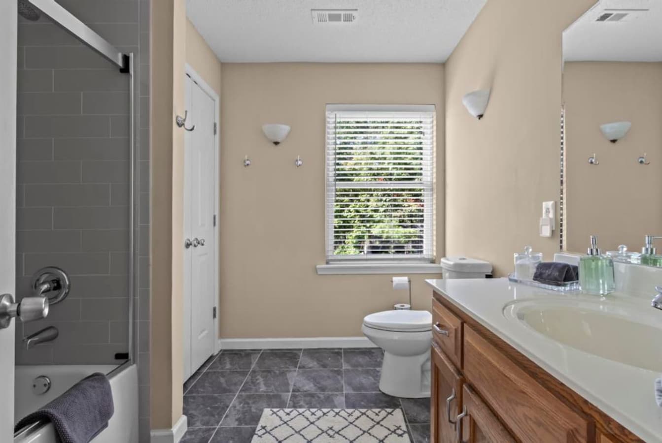 Convenient ensuite bathroom featuring a walk-in shower/tub combo, fresh towels, and all the essentials for your stay.