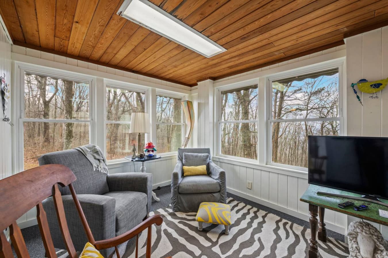 Scenic glass-enclosed lounge with a smart TV—your peaceful getaway spot.